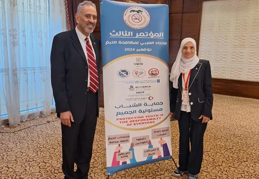 مشاركون بجوار لافتة المؤتمر